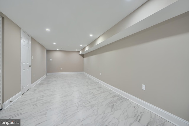 finished basement featuring baseboards, recessed lighting, and marble finish floor