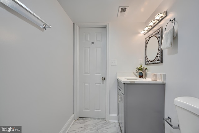 bathroom featuring baseboards, toilet, marble finish floor, and visible vents