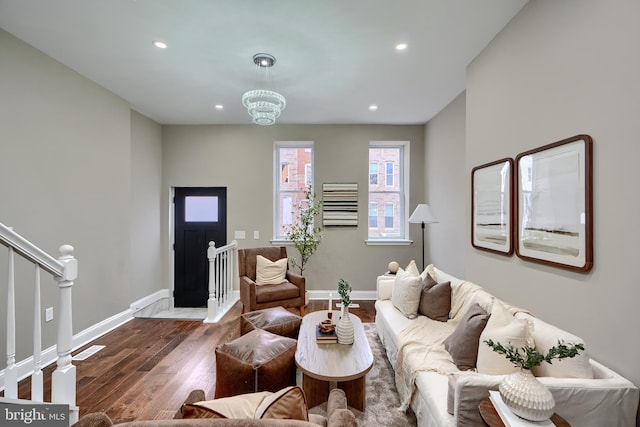 living room featuring baseboards, recessed lighting, wood finished floors, and a chandelier