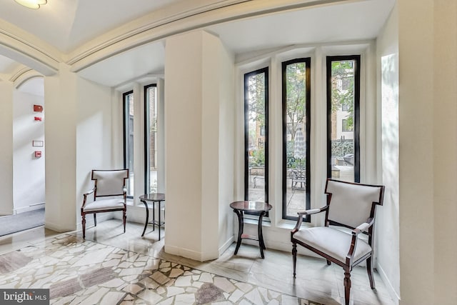 living area featuring arched walkways and baseboards