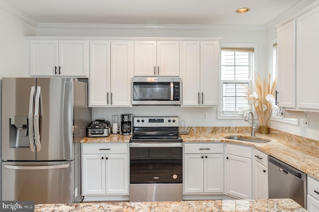 9116 Mineola Ct, Manassas, VA 20111 - kitchen with stainless steel appliances, a sink, white cabinets, ornamental molding, and light stone counters