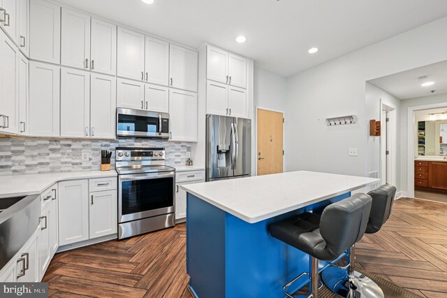 2772 Lighthouse Pt E Unit 410, Baltimore, MD 21224 - kitchen with stainless steel appliances, a breakfast bar area, white cabinetry, light countertops, and recessed lighting