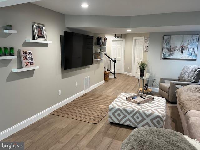 living area with visible vents, wood finished floors, recessed lighting, baseboards, and stairs