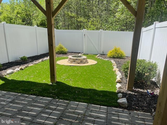 view of yard with a patio, a fenced backyard, and an outdoor fire pit