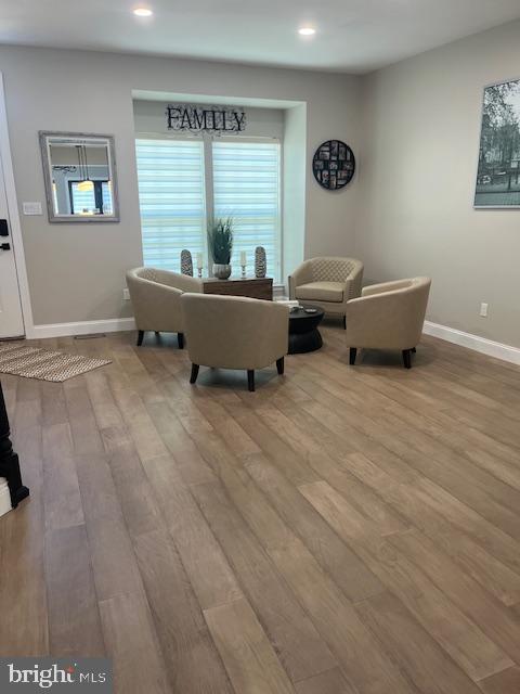 living room featuring baseboards, recessed lighting, and wood finished floors