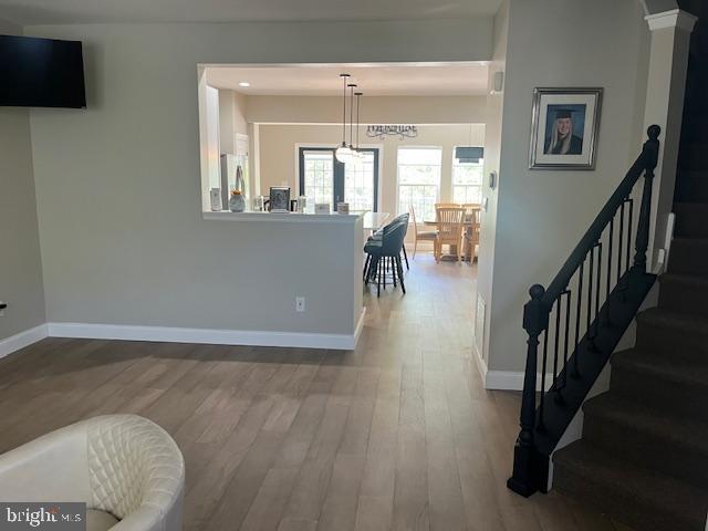 interior space with stairway, baseboards, wood finished floors, and visible vents