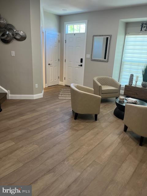 foyer entrance featuring baseboards and light wood-style flooring
