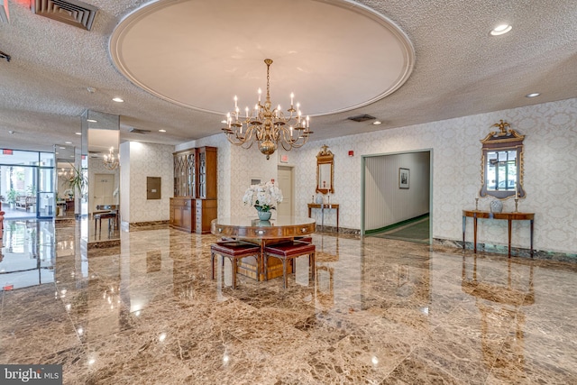 community lobby featuring a textured ceiling and wallpapered walls