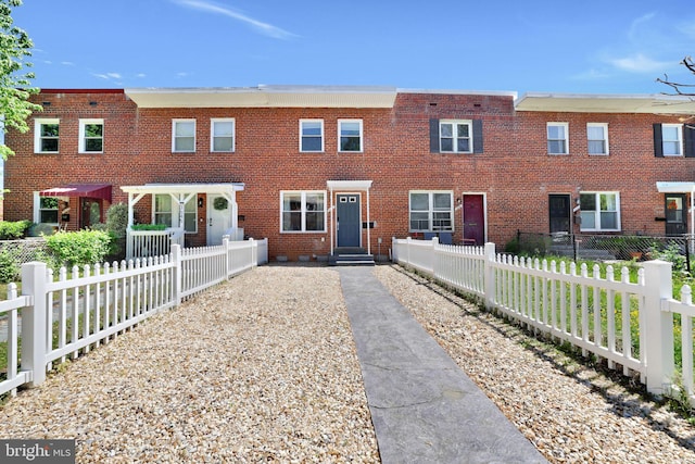 view of front of house featuring entry steps, fence private yard, and brick siding