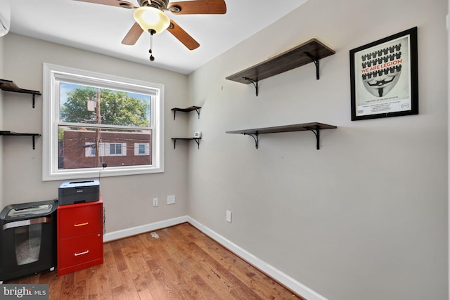 unfurnished office featuring baseboards, a ceiling fan, and light wood-style flooring