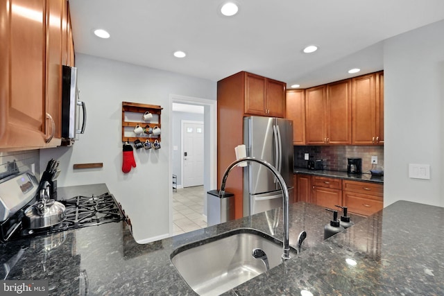 kitchen with backsplash, stainless steel appliances, recessed lighting, and dark stone counters