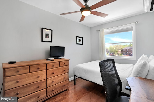 bedroom with baseboards, ceiling fan, and dark wood-type flooring