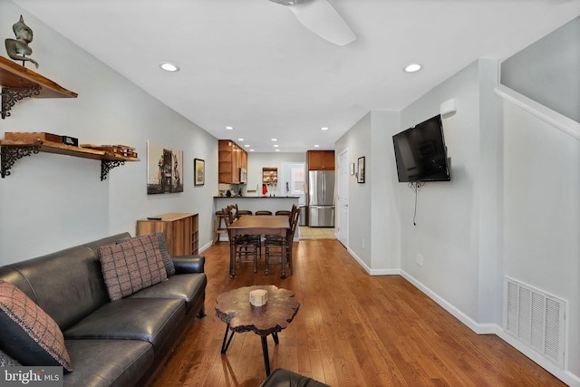 living area featuring recessed lighting, baseboards, visible vents, and light wood finished floors