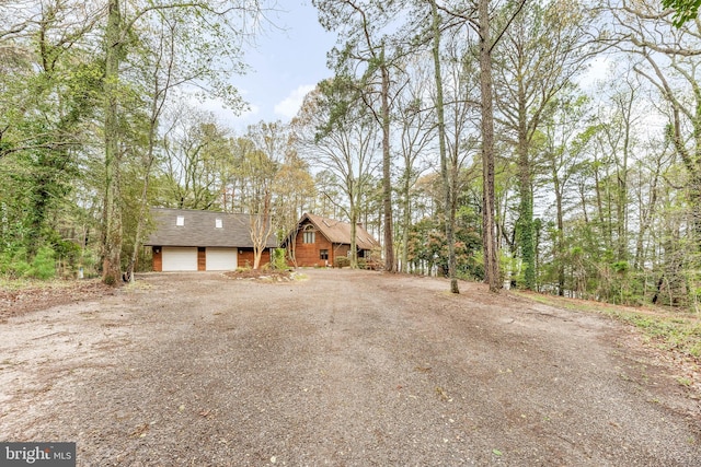 view of front of house with driveway, a shingled roof, and a garage