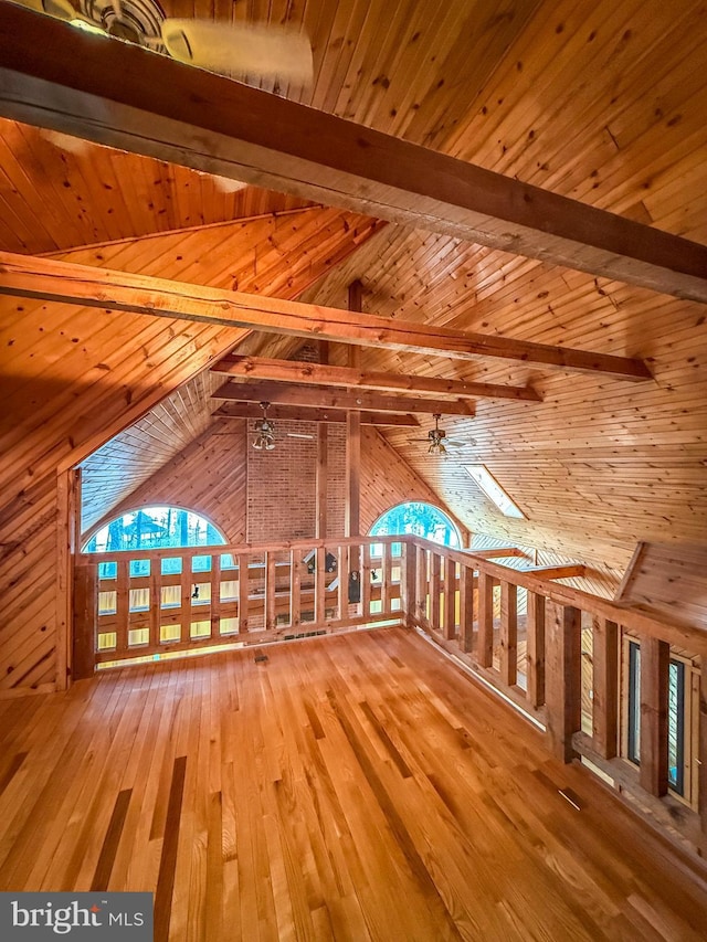 additional living space with beam ceiling, hardwood / wood-style floors, and wooden ceiling