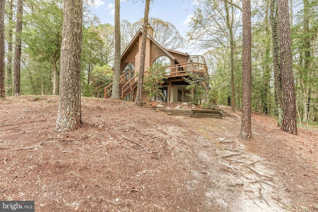 view of home's exterior featuring stairs, a chimney, and a deck
