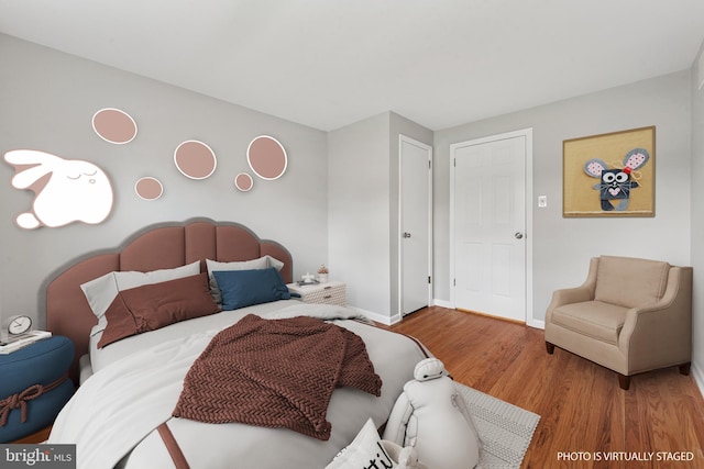 bedroom with baseboards and wood finished floors