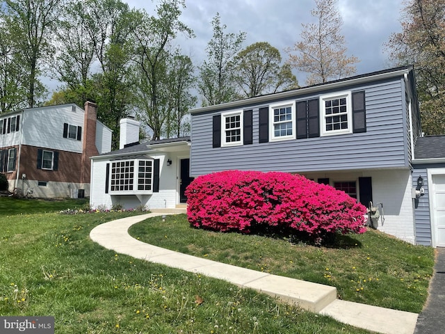 view of front of home featuring brick siding and a front yard
