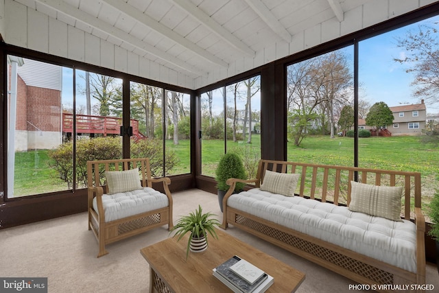 sunroom featuring carpet floors, outdoor lounge area, and plenty of natural light