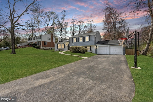 view of front of property featuring a garage, a yard, driveway, and fence