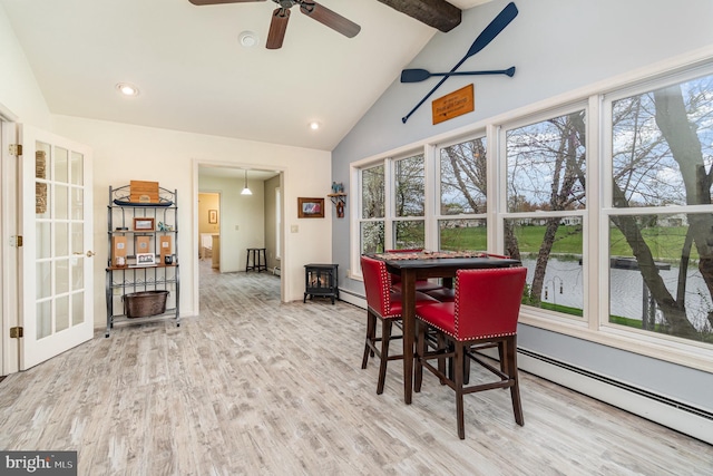 dining space with high vaulted ceiling, wood finished floors, a water view, beamed ceiling, and a baseboard heating unit