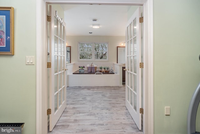hallway with french doors and wood finished floors