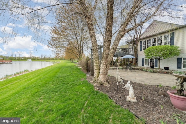 view of yard with a water view and a patio area