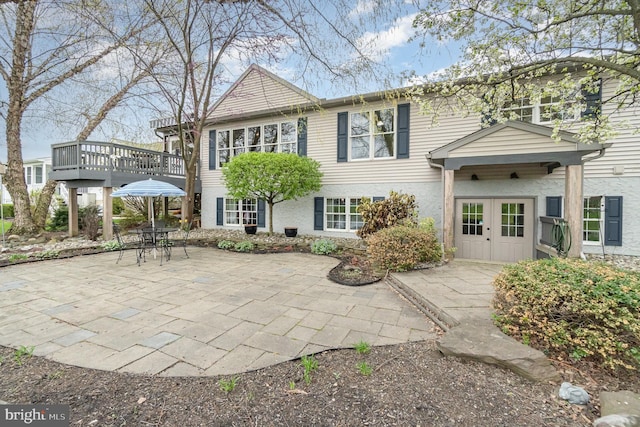 rear view of property featuring a patio area and a deck