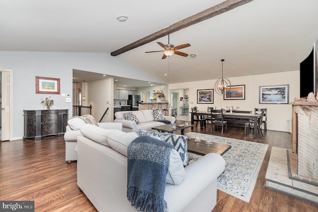 living area with lofted ceiling with beams, ceiling fan with notable chandelier, and wood finished floors