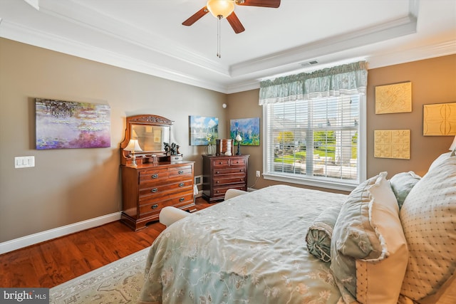 44451 Cruden Bay Dr, Ashburn, VA 20147 - bedroom featuring crown molding, visible vents, wood finished floors, baseboards, and a tray ceiling