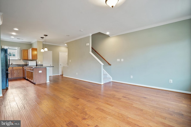 22788 Sagamore Sq, Brambleton, VA 20148 - unfurnished living room featuring light wood finished floors, stairs, baseboards, ornamental molding, and recessed lighting