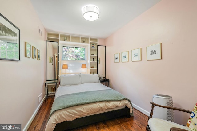 bedroom featuring baseboards, visible vents, and wood finished floors