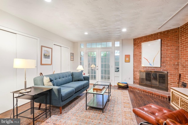 living room featuring a fireplace, recessed lighting, and wood finished floors