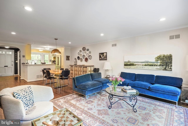 living room featuring arched walkways, ornamental molding, recessed lighting, and wood finished floors