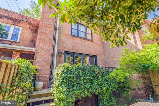 exterior space featuring brick siding and fence