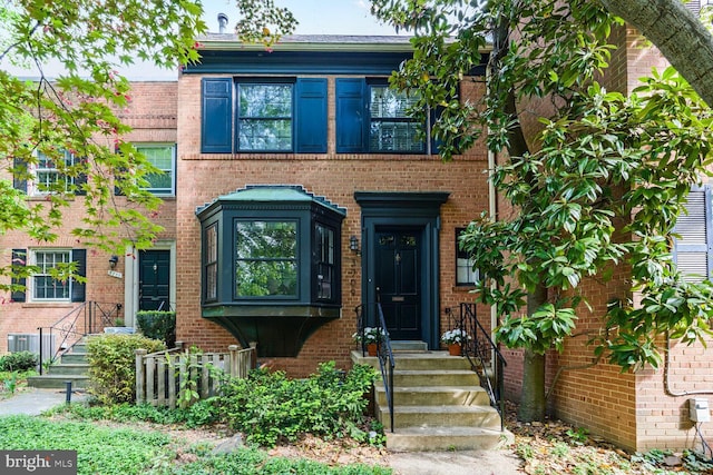 view of property featuring central air condition unit and brick siding