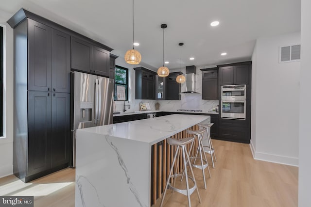 1904 Jackson St NE, Washington, DC 20018 - kitchen with visible vents, wall chimney exhaust hood, a sink, light wood-style flooring, and stainless steel appliances