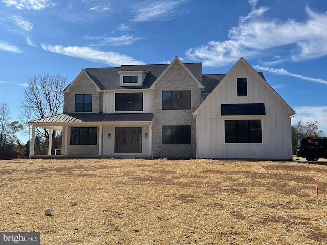 modern inspired farmhouse featuring board and batten siding, metal roof, and a standing seam roof