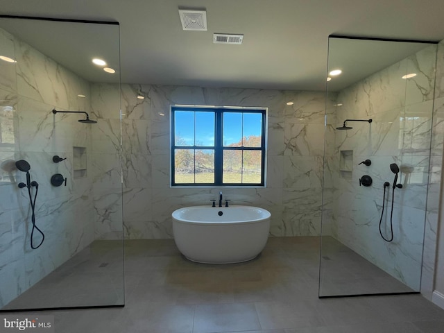full bath with a freestanding tub, visible vents, a marble finish shower, and tile patterned flooring