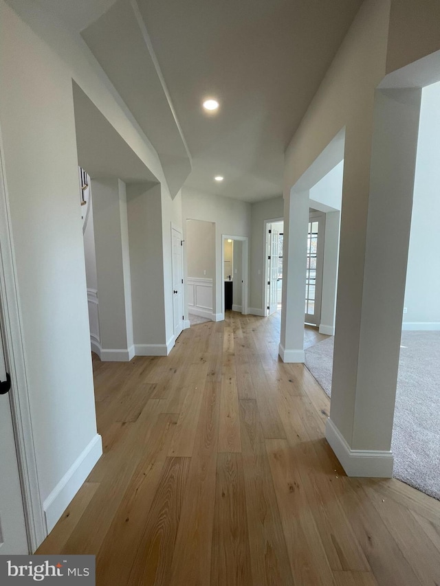 hallway featuring baseboards, recessed lighting, and light wood-type flooring