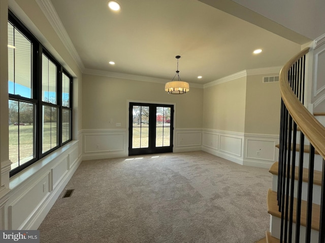 empty room with visible vents, a decorative wall, and a wealth of natural light