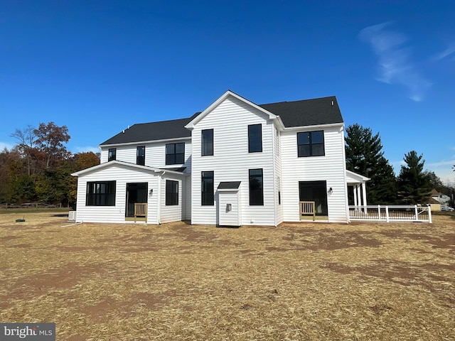 back of house with roof with shingles