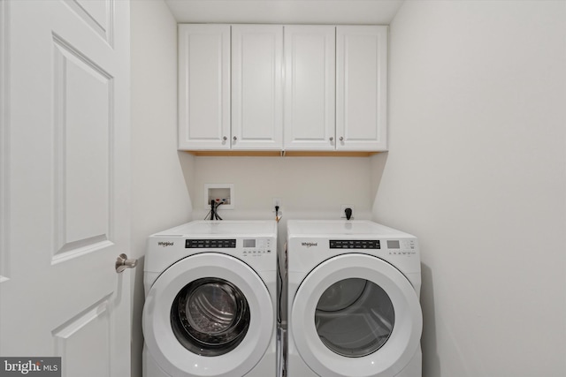 clothes washing area featuring cabinet space and washer and dryer