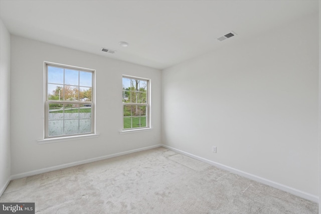 unfurnished room with visible vents, carpet, and baseboards