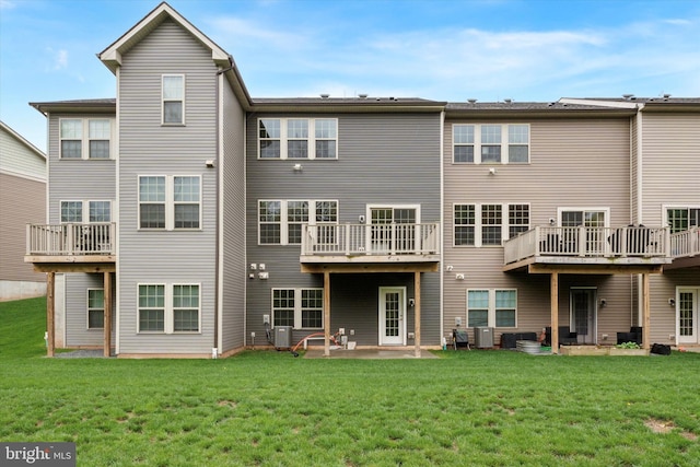 back of house featuring a lawn and central AC unit