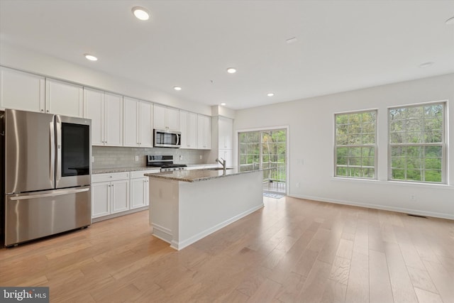 kitchen featuring a sink, white cabinetry, light wood-style flooring, and stainless steel appliances