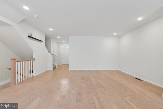 empty room with recessed lighting, baseboards, light wood-type flooring, and visible vents