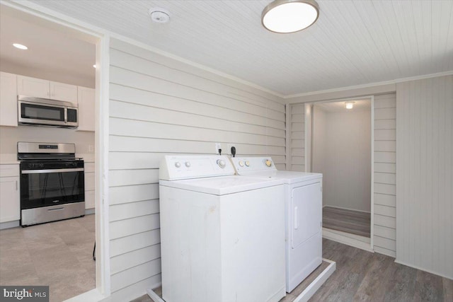 223 Henry St, Cambridge, MD 21613 - clothes washing area with ornamental molding, laundry area, wood walls, and independent washer and dryer