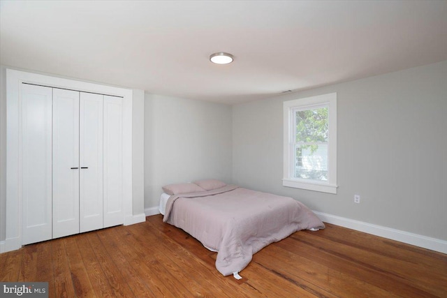 223 Henry St, Cambridge, MD 21613 - bedroom with baseboards, wood finished floors, and a closet