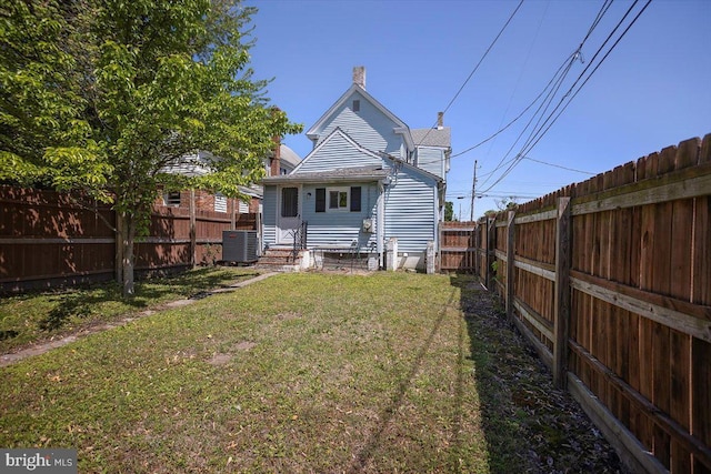 223 Henry St, Cambridge, MD 21613 - rear view of house with central air condition unit, a yard, a chimney, and a fenced backyard